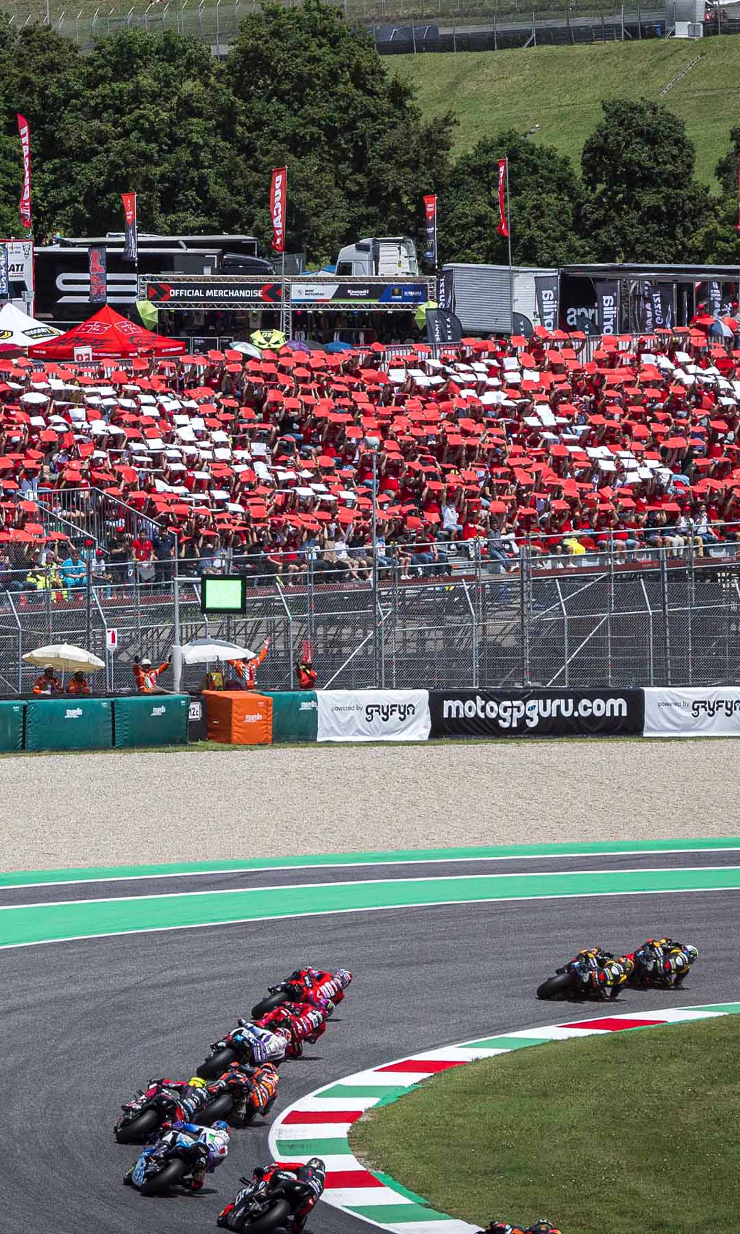 tribuna Ducati al circuito del Mugello, con piloti in curva che scorrono via