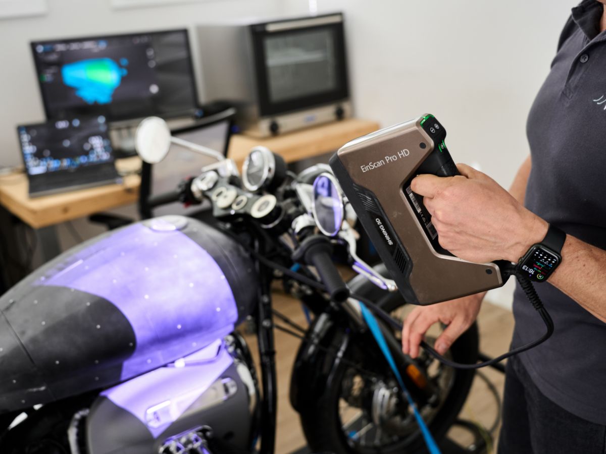 Un operaio ed una moto viola negli uffici di Wheelab.