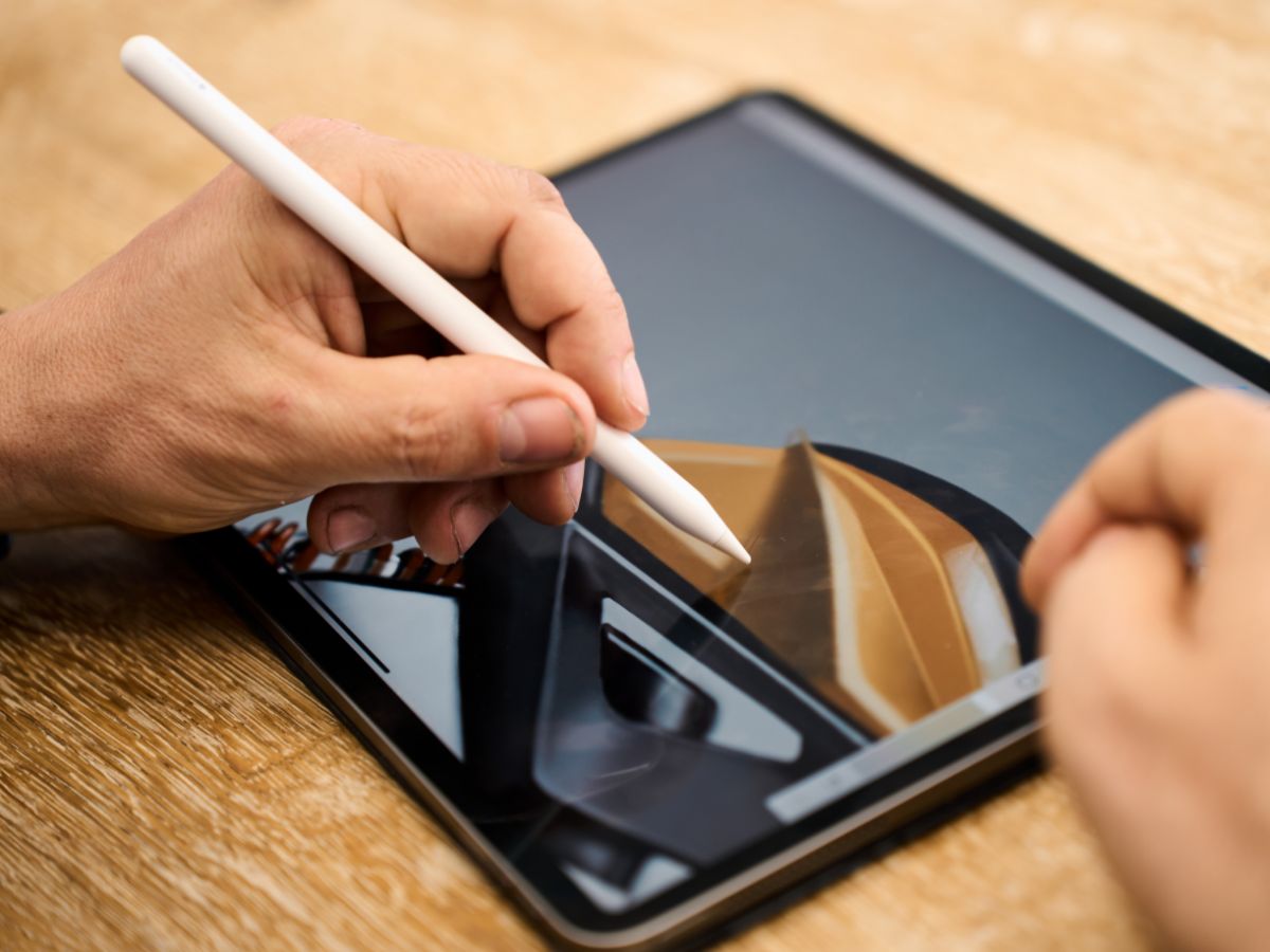 Persona che scrive con penna apposita sul tablet.