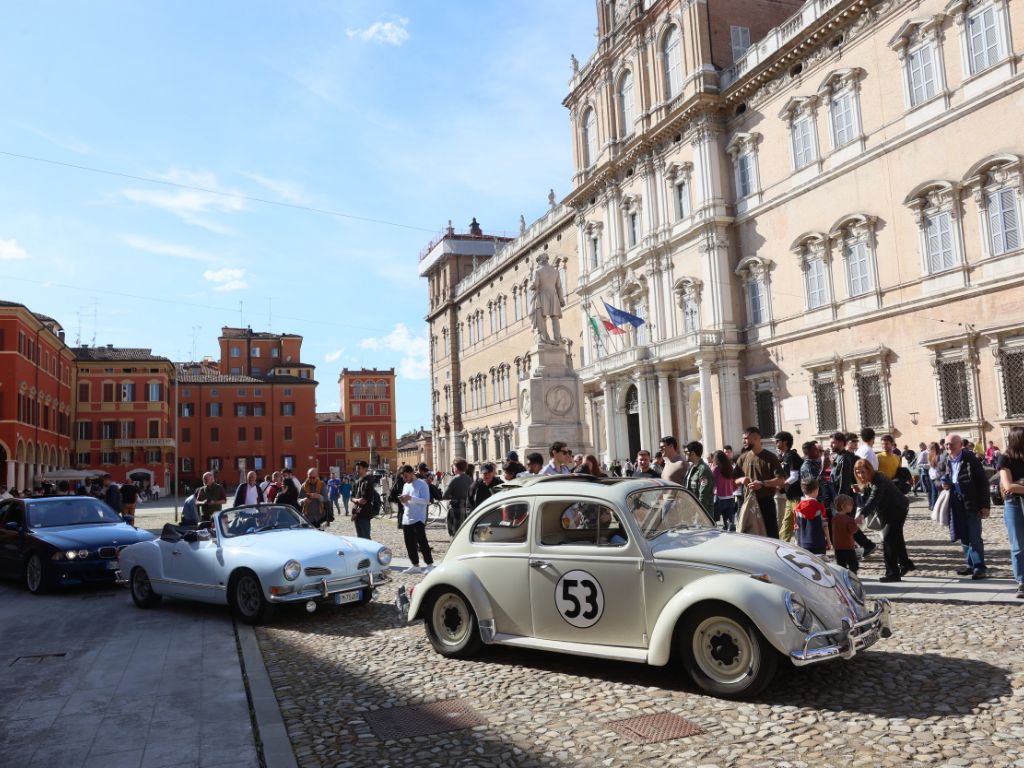 Auto d'epoca in piazza a Modena con pubblico.