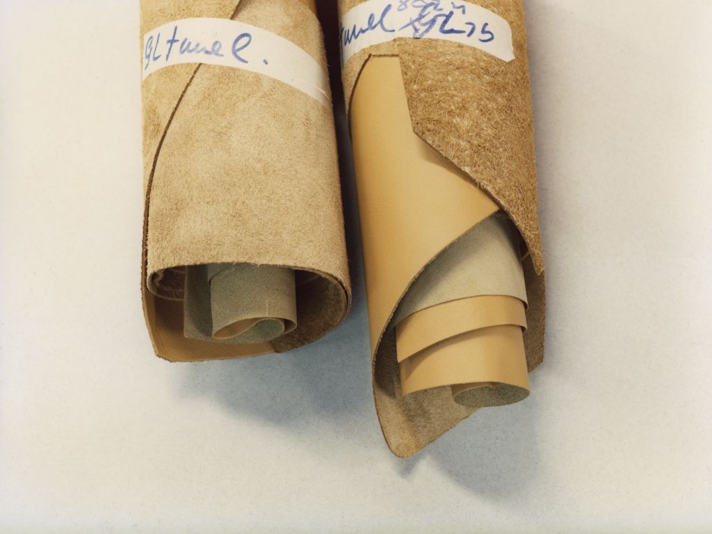 2 rotoli di tessuto beige su un tavolo bianco.