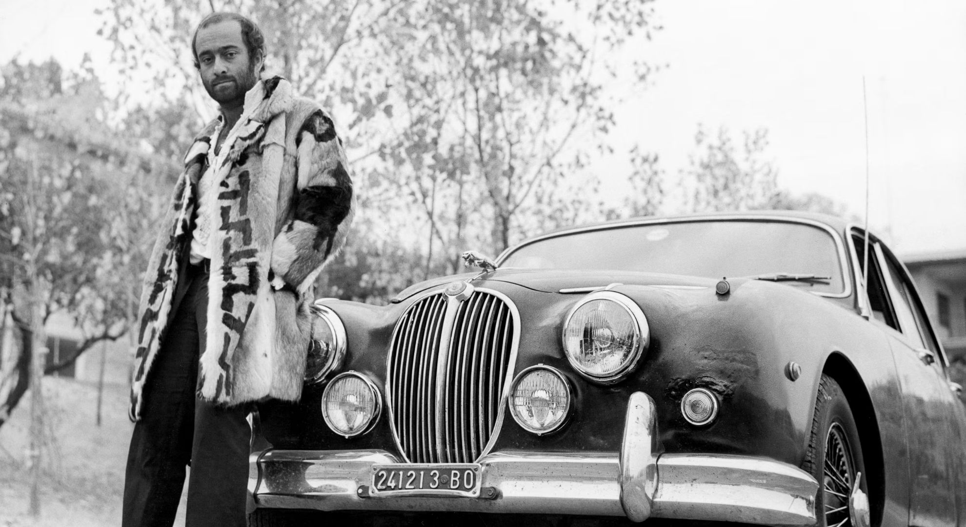 Lucio Dalla appoggiato alla sua automobile.