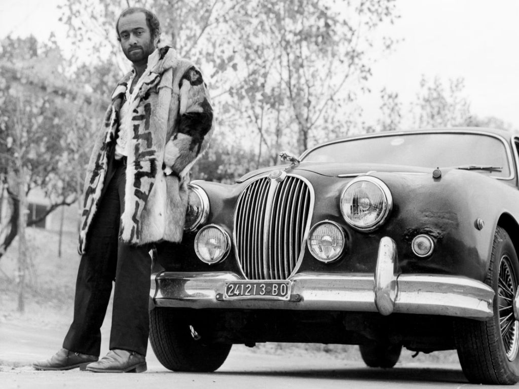 Lucio Dalla appoggiato alla sua automobile.