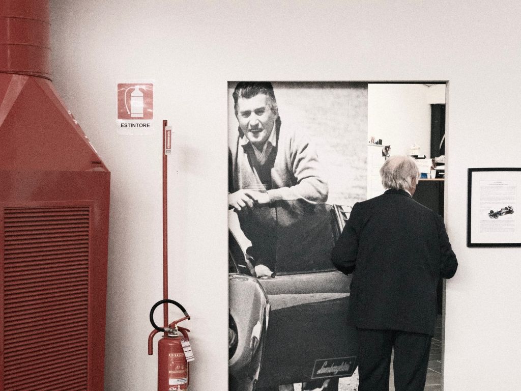 Tonino Lamborghini apre una porta scorrevole con una stampa del padre Ferruccio dipinta sopra.