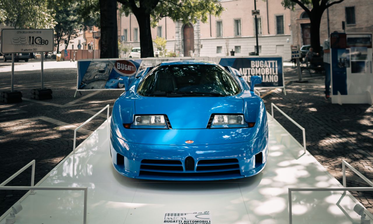 Foto frontale di una Bugatti su un piedistallo di piazza.