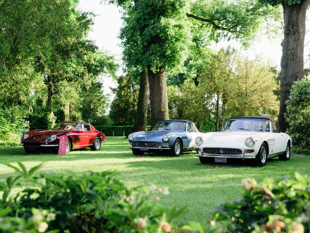 Storiche vetture Ferrari parcheggiate in un giardino.