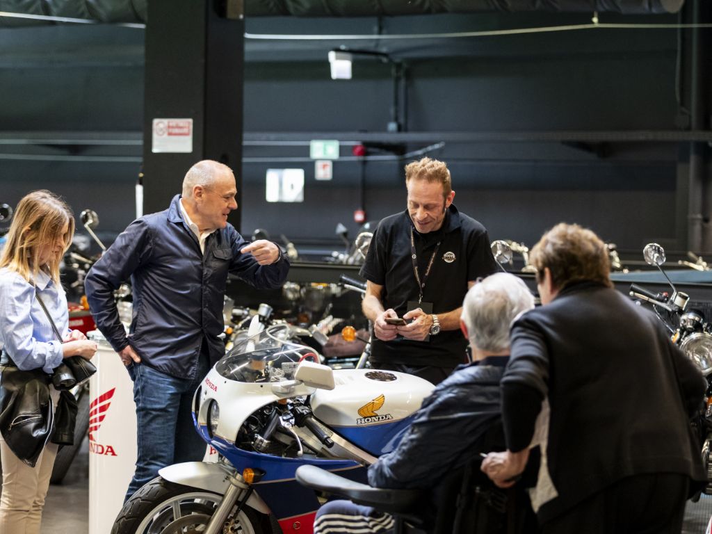 Visitatori osservano una moto Honda esposta a Ruote da Sogno.