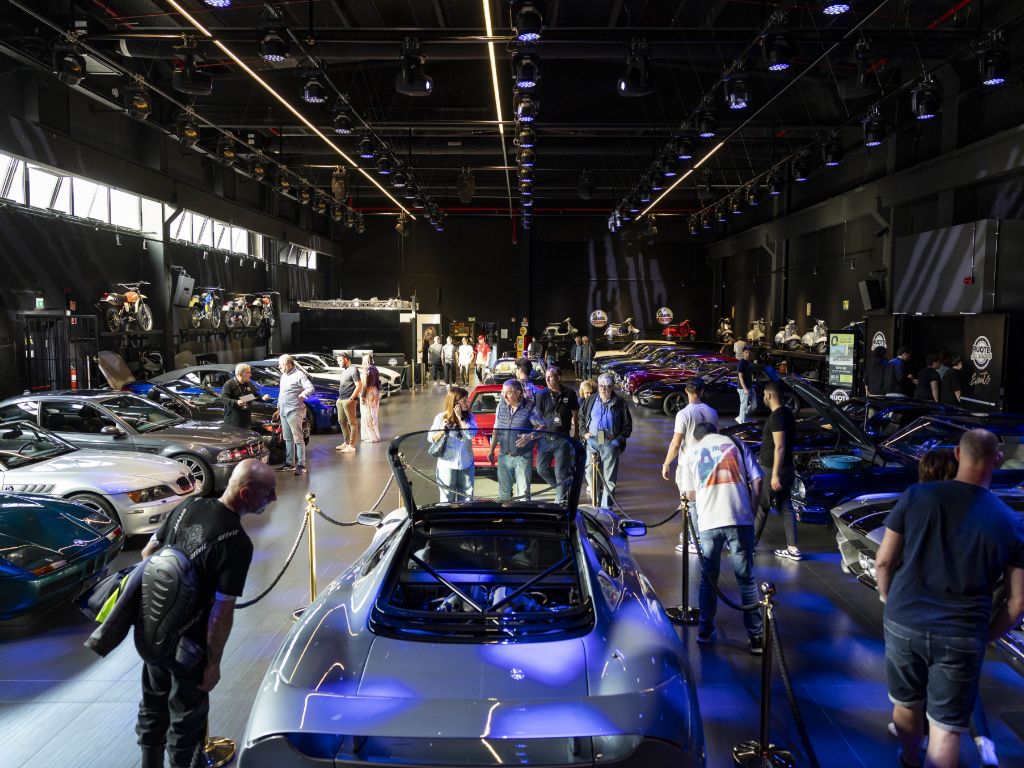 Persone osservano le vetture esposte allo showroom Ruote da Sogno.
