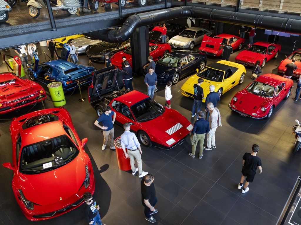 Persone osservano le vetture esposte allo showroom Ruote da Sogno.