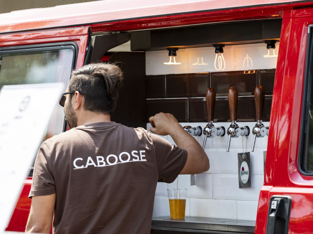Barista di Caboose spilla una birra in un truck a Ruote da Sogno.