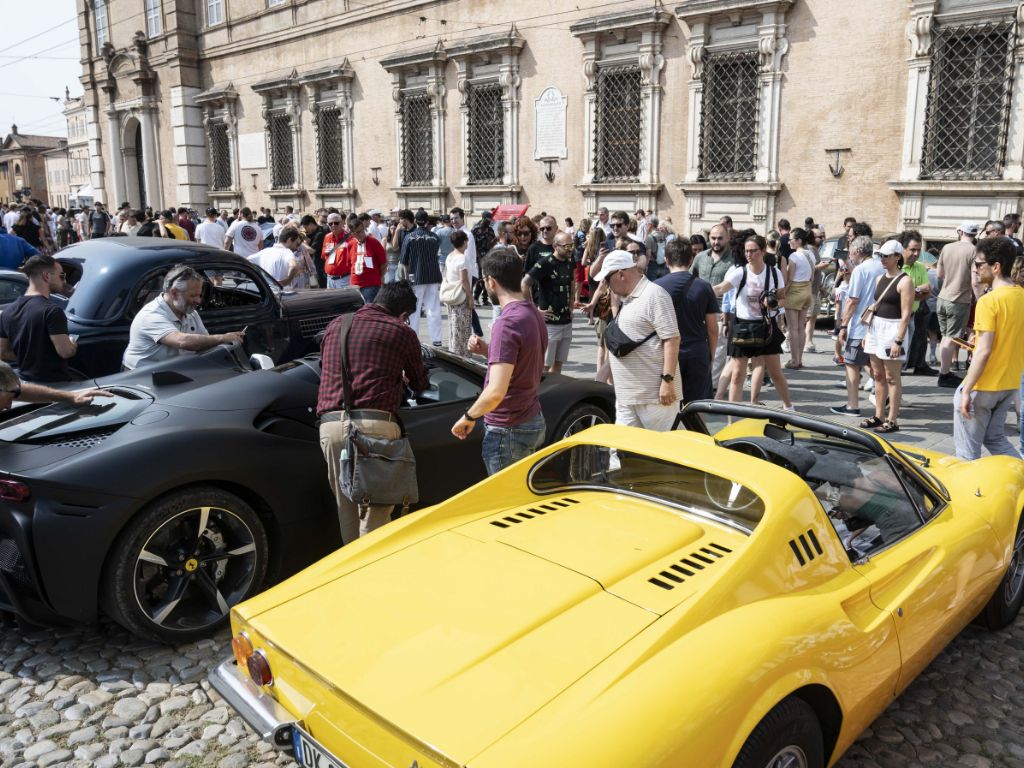 Macchine d'epoca in piazza a Modena, circondate dalla folla del Motor Valley Fest 2025.