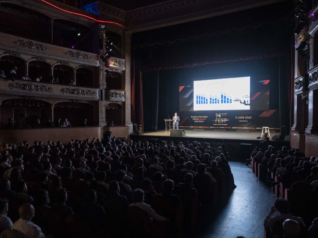 Teatro Storchi, Modena, convegno inaugurale del Motor Valley Fest 2025: la platea assiste ad un discorso sul palco illuminato.
