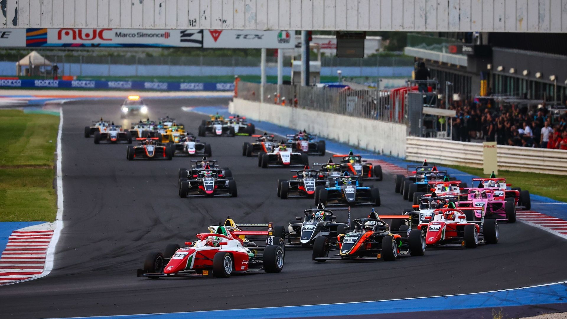 Gruppo di vetture sfrecciano al Misano World Circuit durante l'ACI Racing Weekend.