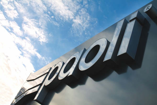 Insegna aziendale esterna con il logo "Paoli" in lettere tridimensionali stagliate contro un cielo azzurro con nuvole leggere.