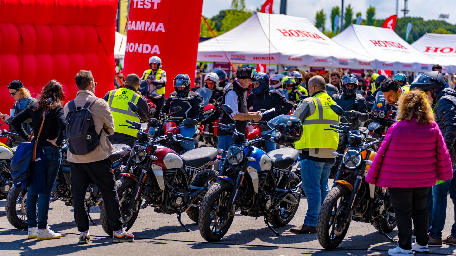 Serie di moto con persone intorno durante l'EICMA a Misano.