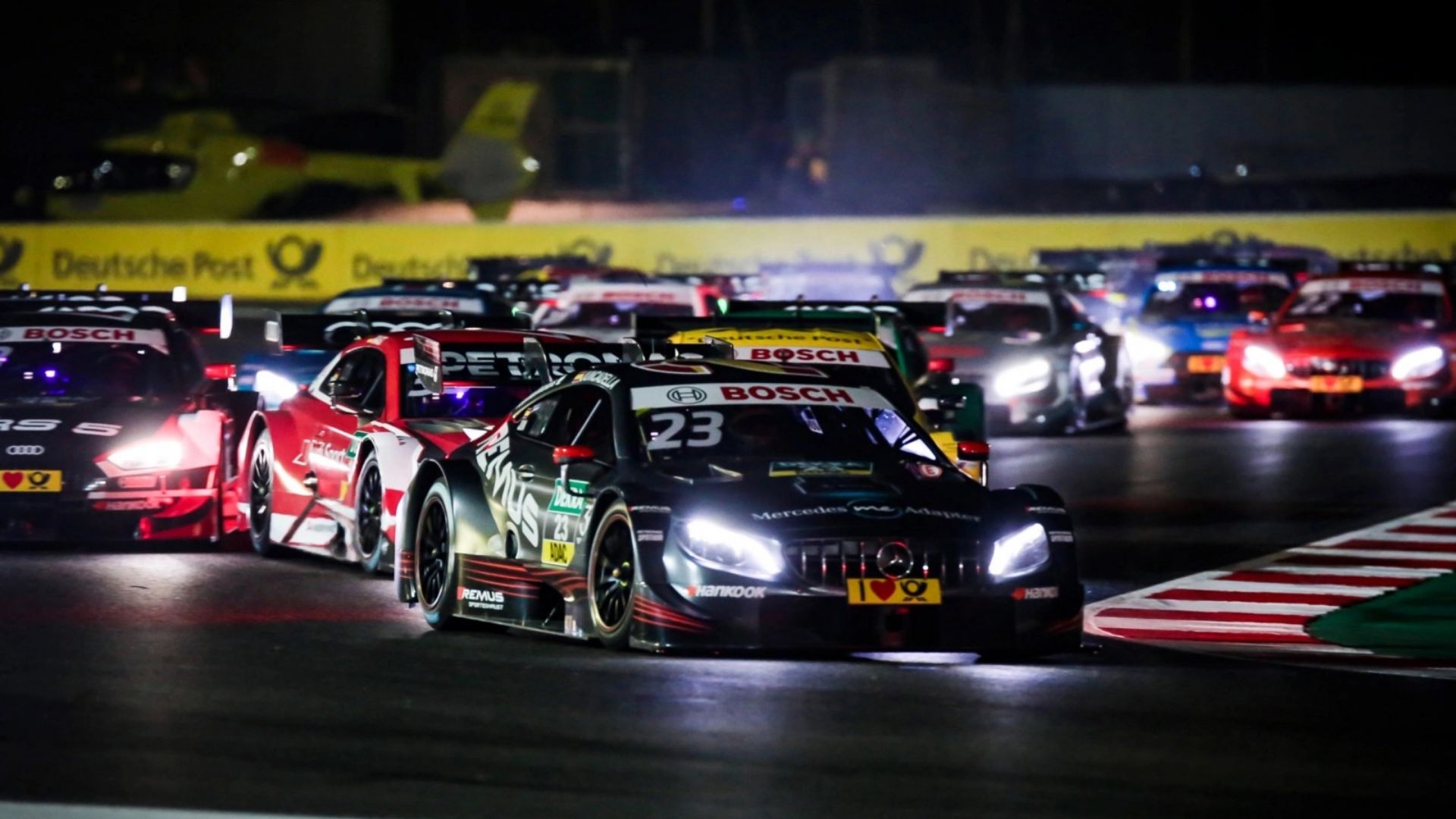 Le vetture del GT World Challenge sfrecciano in pista a Misano di notte.