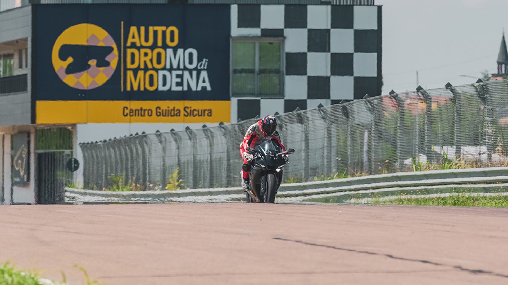 Un pilota in sella alla sua moto affronta un rettilineo all'Autodromo di Modena.