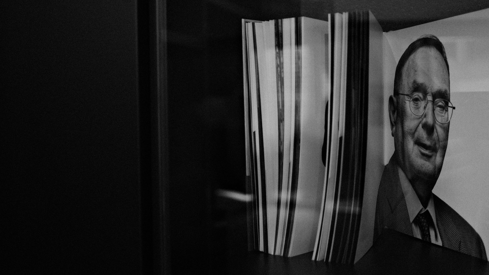 Libri e cataloghi esposti alla Dallara Academy con il ritratto in bianco e nero dell'Ingegner Giampaolo Dallara.