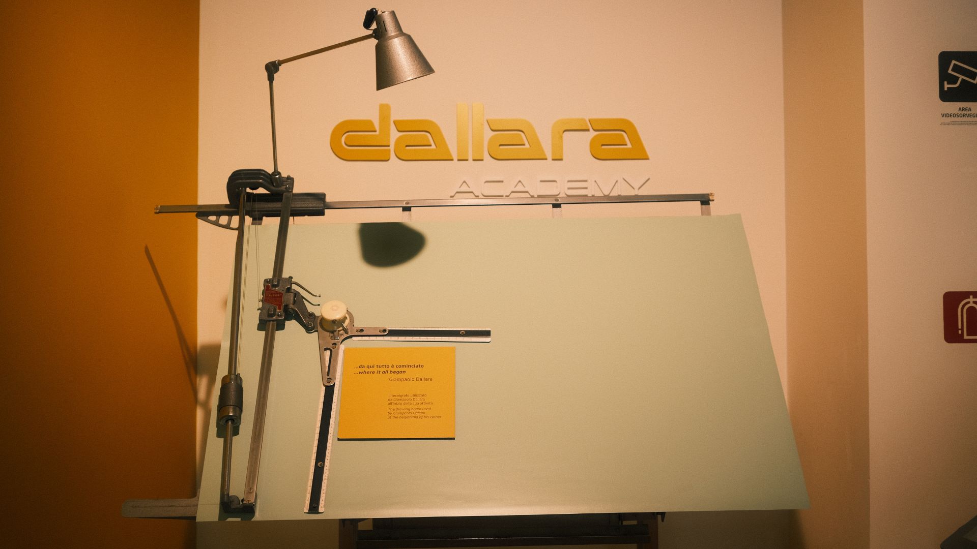 Il tecnigrafo storico di Giampaolo Dallara esposto sotto il logo ufficiale retroilluminato della Dallara Academy.