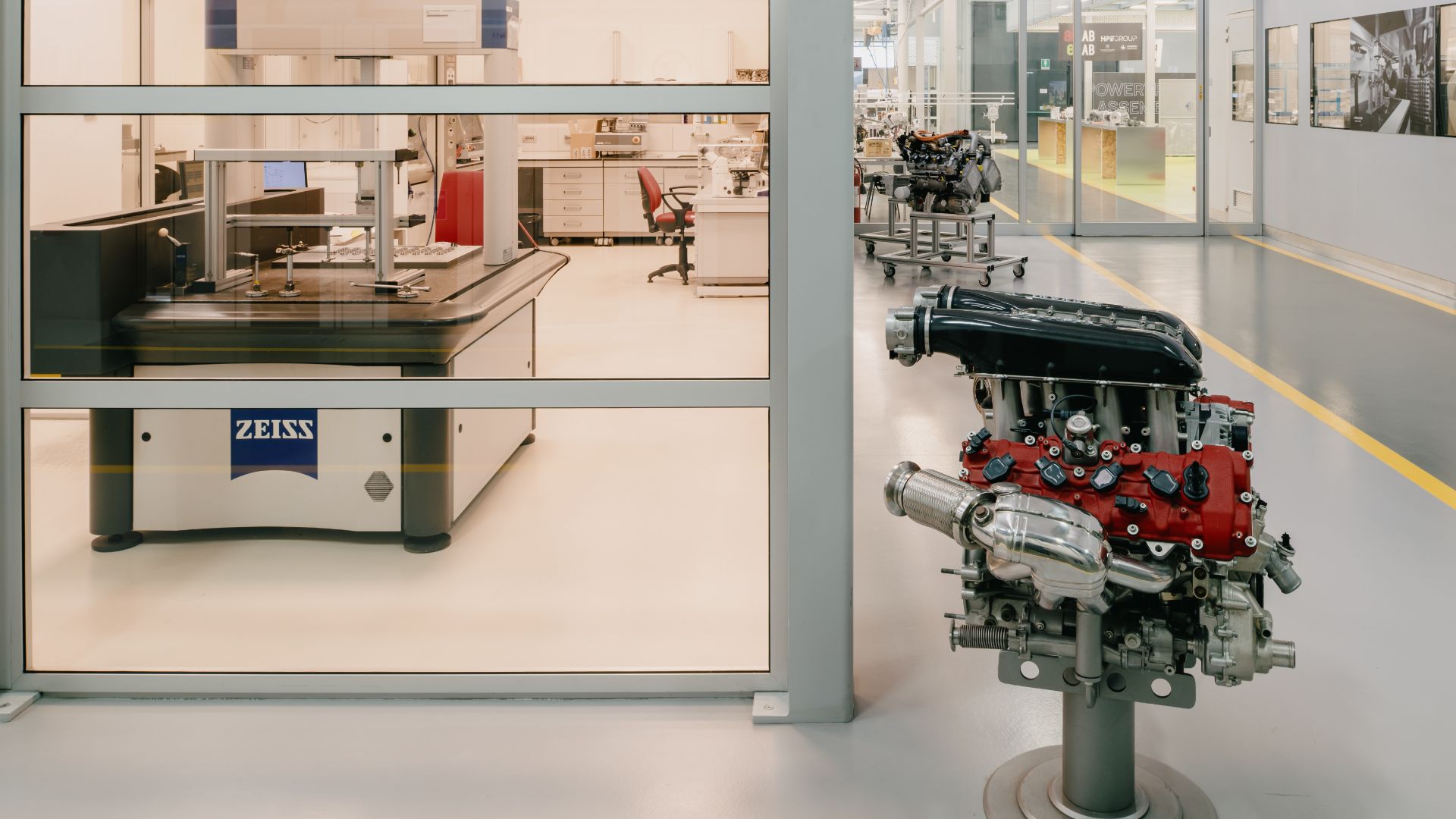 Motore ad alte prestazioni su supporto con sala metrologica e macchinari di misura Zeiss sullo sfondo