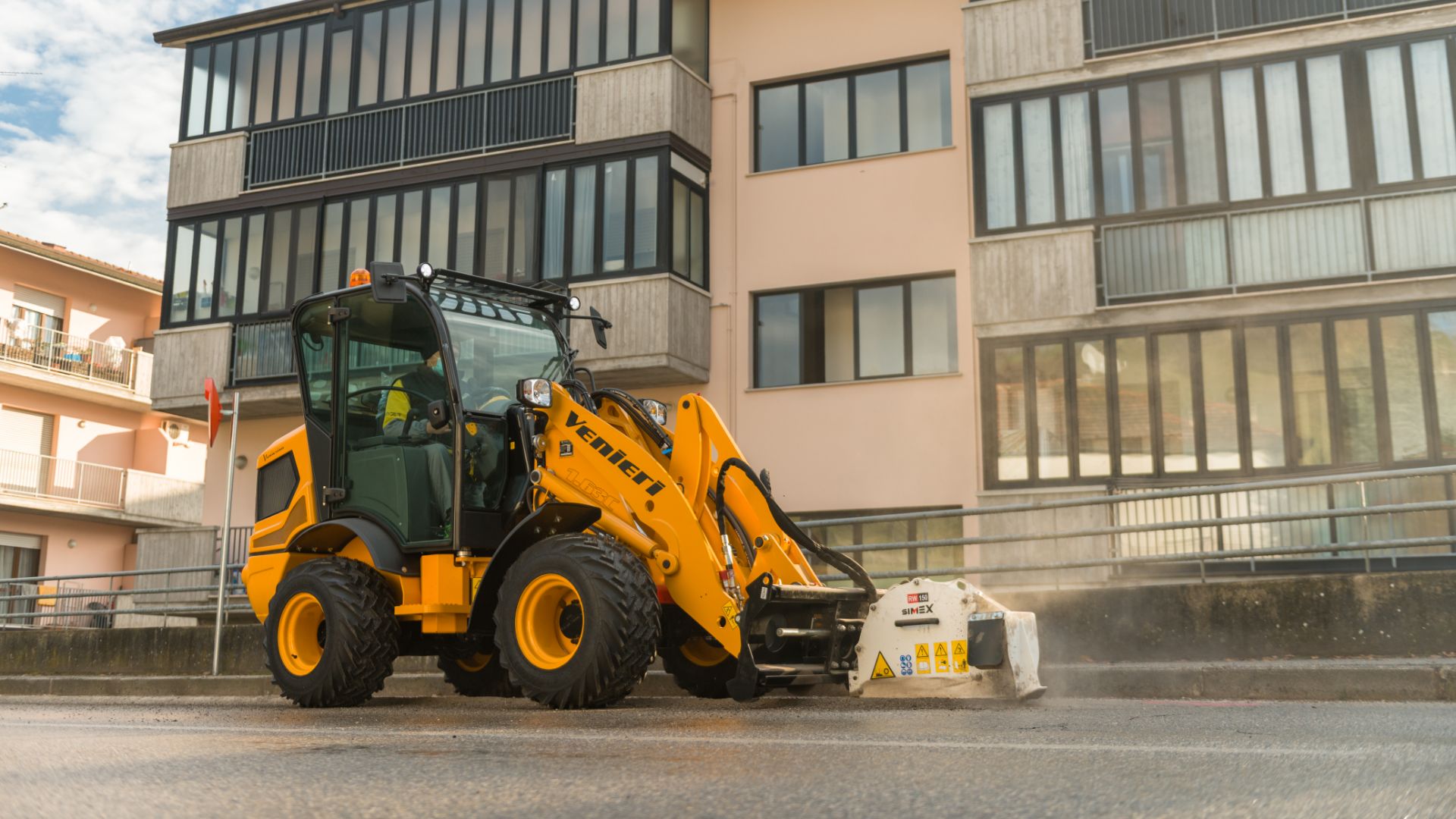 Pala gommata compatta Venieri 1.63T con fresa stradale Simex per il ripristino dell'asfalto in centro urbano
