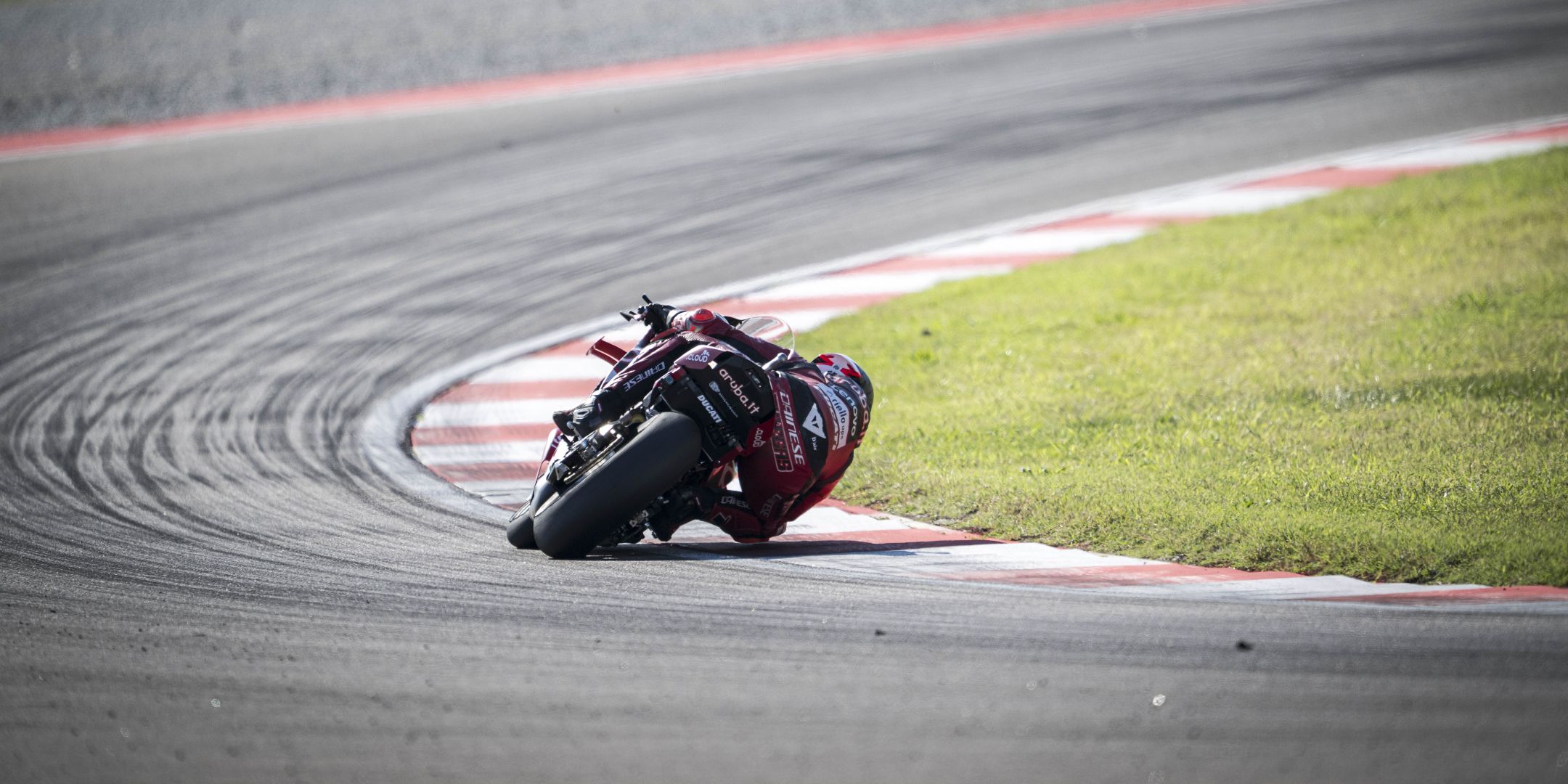 Nicolò Bulega in piega estrema con la sua Ducati rossa durante una competizione in circuito.