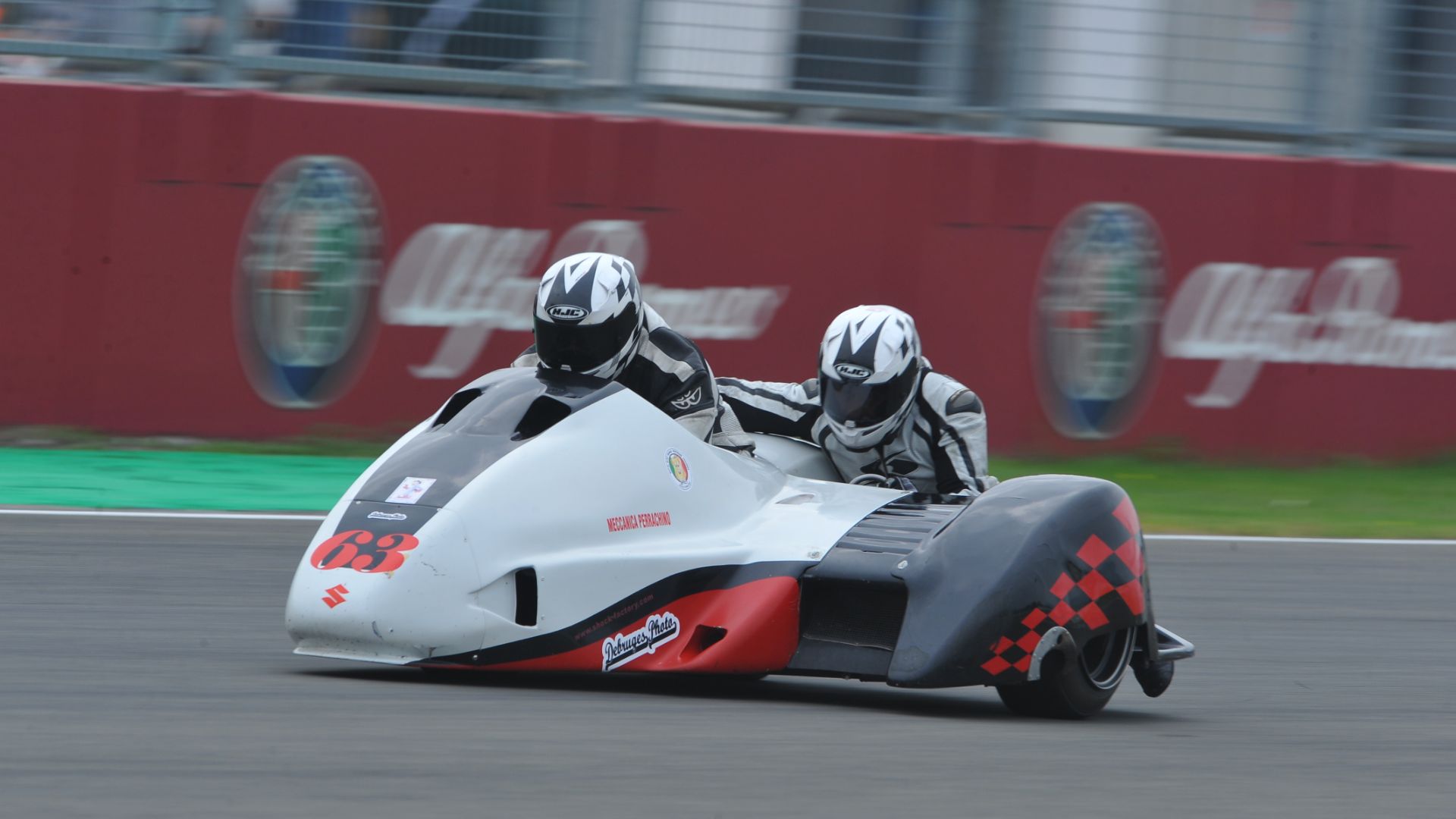 Sidecar da corsa numero 68 in azione su pista con due piloti.